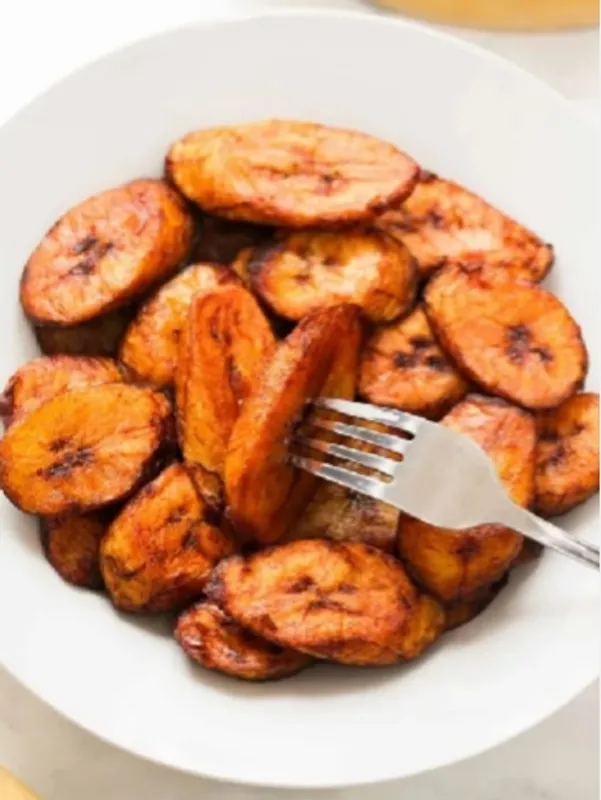 Golden fried plantain slices in a white bowl